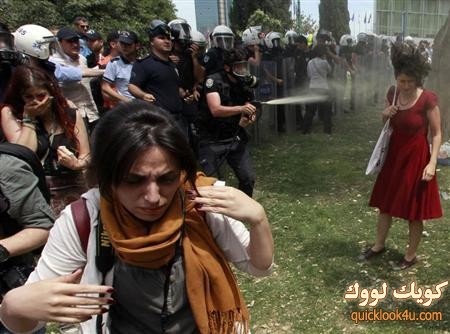 Turkish riot policeman uses tear gas during a protest in central Istanbul